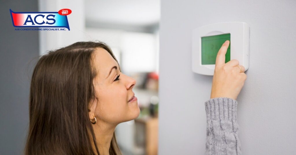 Keep Cool This Summer woman checking thermostat