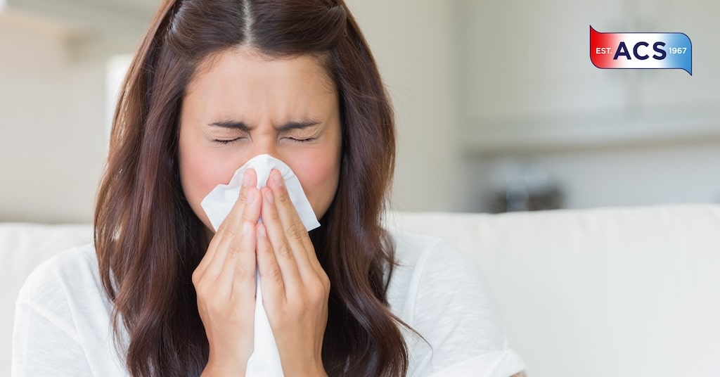 Woman sneezing as she needs an air purification system